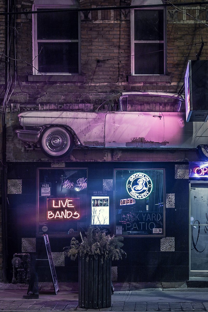 Old Car Mounted Against Side of Building